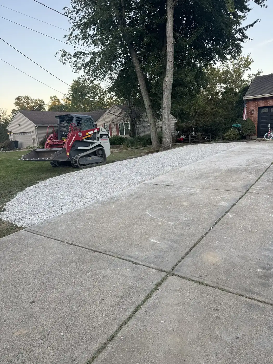 Phelps track loader spreading gravel on a residential driveway