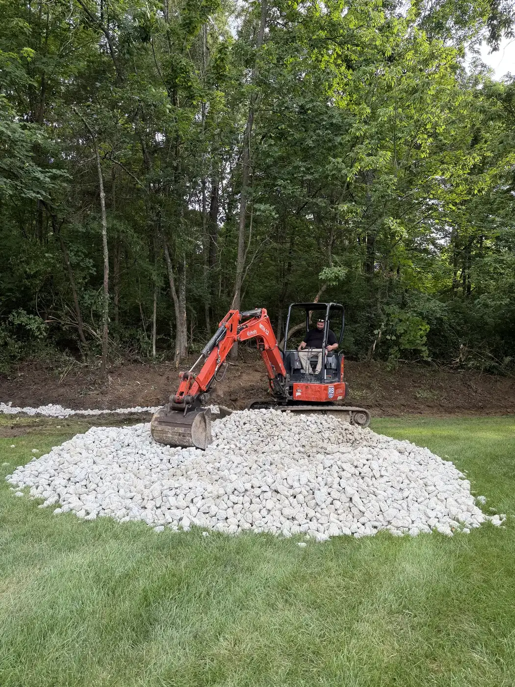 Phelps excavator working a gravel pile on a property project